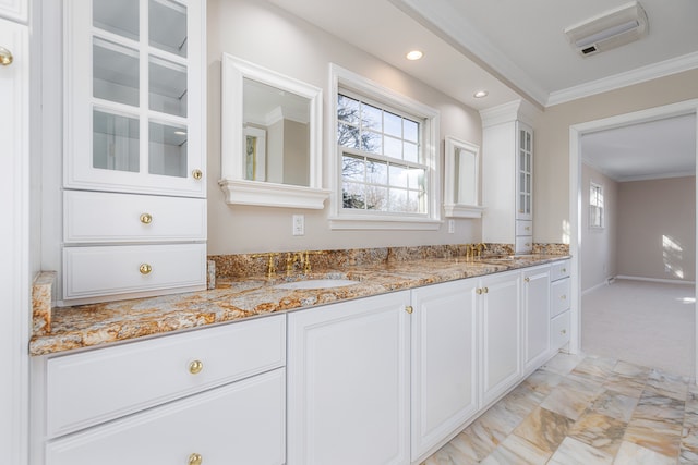 kitchen featuring light stone countertops, crown molding, white cabinets, and sink