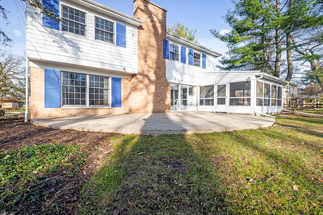 rear view of house with a yard, a patio area, and a sunroom