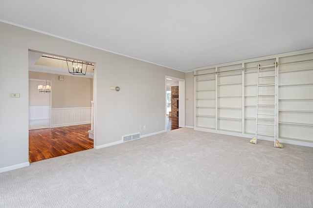 unfurnished bedroom with wood-type flooring, a notable chandelier, and ornamental molding