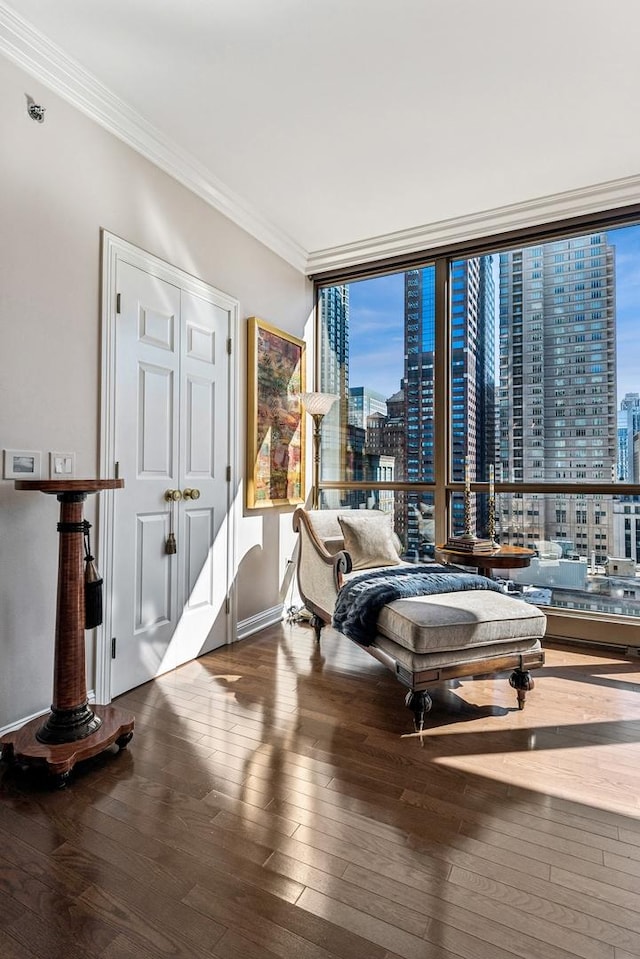 sitting room featuring hardwood / wood-style flooring, a wall of windows, and crown molding