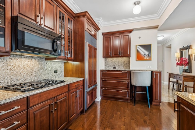 kitchen featuring stainless steel gas stovetop, light stone countertops, decorative backsplash, and ornamental molding