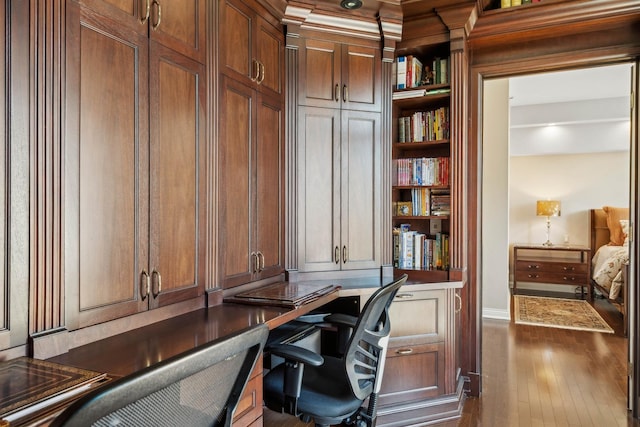 office featuring dark hardwood / wood-style flooring and built in desk