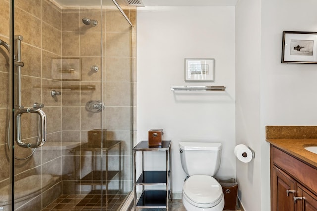 bathroom with vanity, toilet, and a shower with shower door