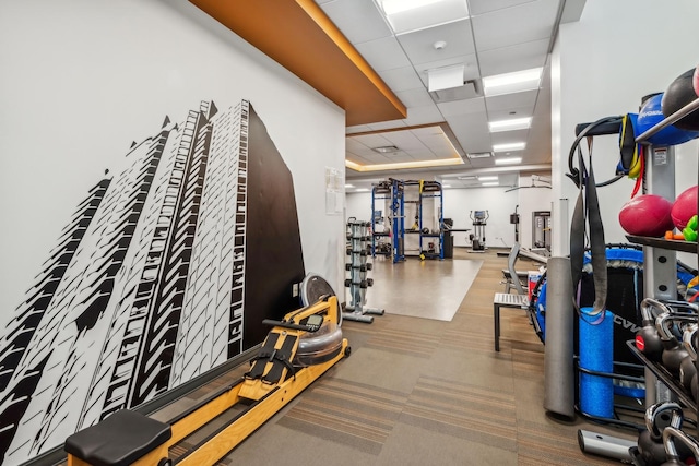 workout area with carpet flooring and a drop ceiling