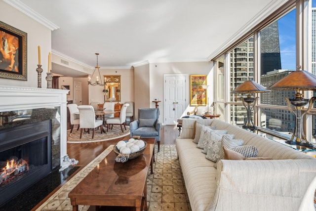 living room with light hardwood / wood-style floors, ornamental molding, and a high end fireplace