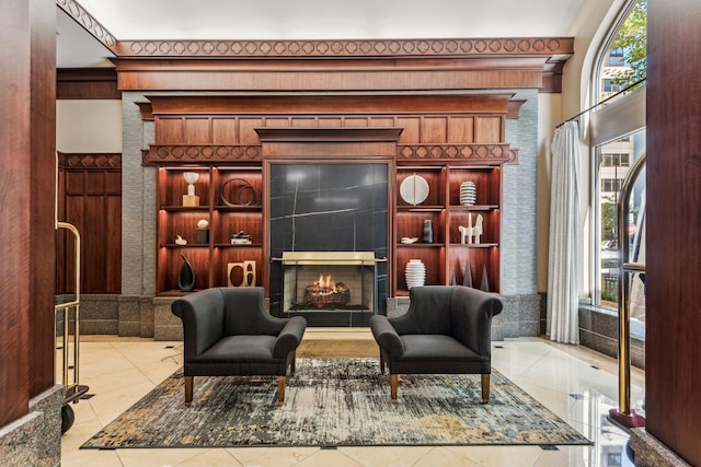 sitting room featuring a tiled fireplace and built in features