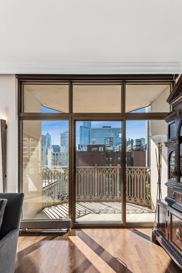 doorway with wood-type flooring, floor to ceiling windows, and crown molding