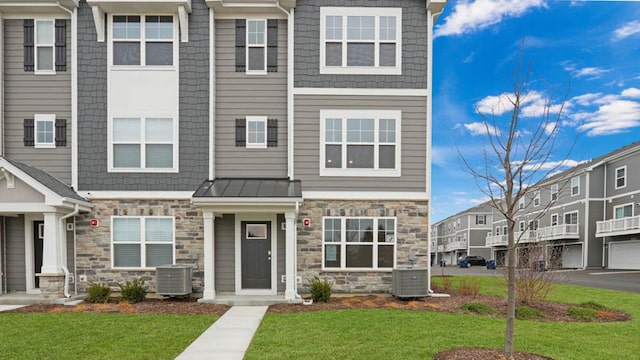 multi unit property featuring cooling unit and a front yard