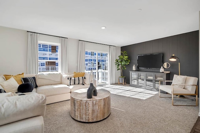 living room with carpet floors and wooden walls