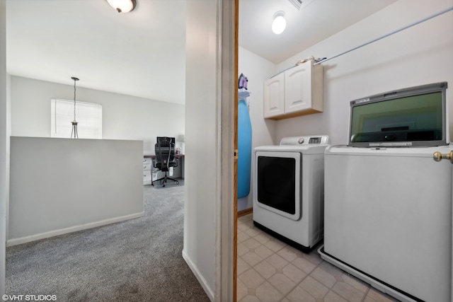 clothes washing area with cabinets, washing machine and dryer, and light colored carpet