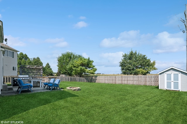 view of yard with a storage shed, a patio, and an outdoor fire pit