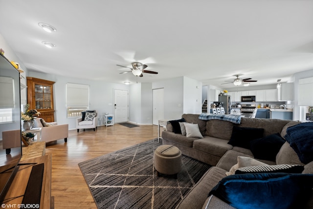 living room featuring ceiling fan and light wood-type flooring