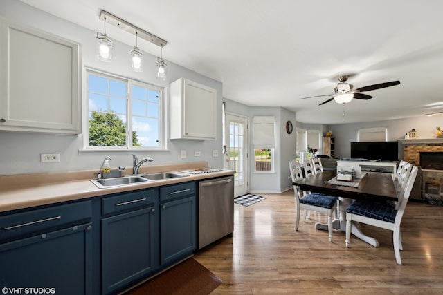 kitchen featuring stainless steel dishwasher, blue cabinetry, pendant lighting, hardwood / wood-style floors, and white cabinetry