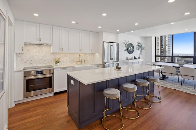 kitchen featuring stainless steel appliances, dark wood-type flooring, and white cabinetry