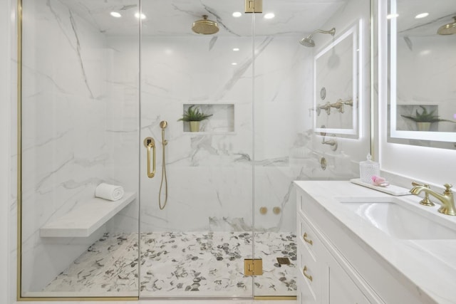 bathroom featuring a marble finish shower and vanity