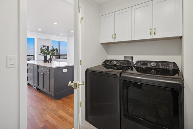 180 E Pearson St Unit 5401, Chicago, IL 60611 - laundry area featuring separate washer and dryer, recessed lighting, cabinet space, and light wood-type flooring