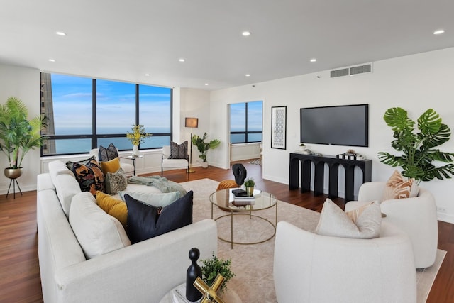 living area with a wealth of natural light, wood finished floors, visible vents, and recessed lighting