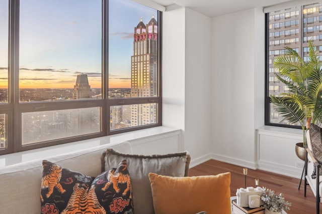 sitting room with baseboards, wood finished floors, and a city view