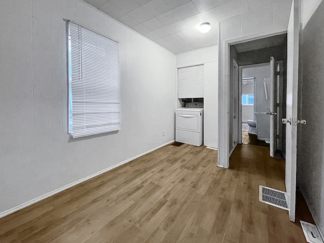 laundry area featuring washer / dryer, wood-type flooring, and wooden walls