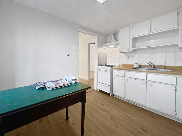 kitchen featuring white cabinetry, gas range gas stove, sink, extractor fan, and light wood-type flooring