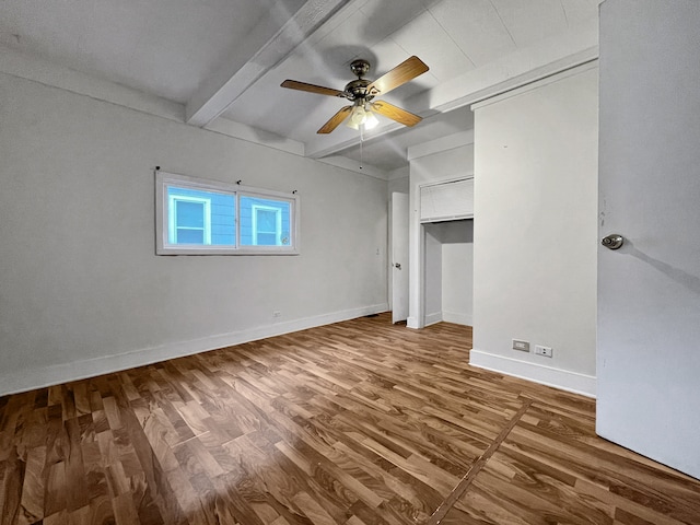 unfurnished bedroom featuring hardwood / wood-style flooring, ceiling fan, and beam ceiling