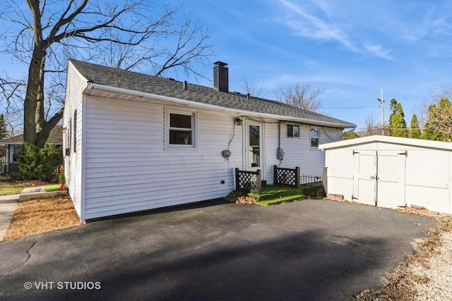 view of front of property with a storage shed