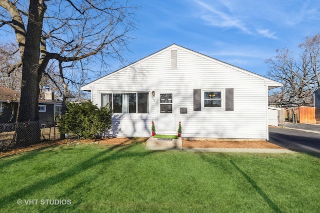 rear view of property featuring a yard