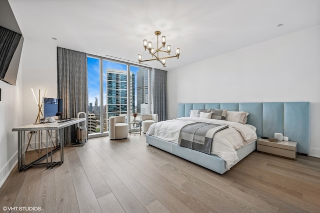 bedroom featuring light hardwood / wood-style flooring, expansive windows, and a notable chandelier