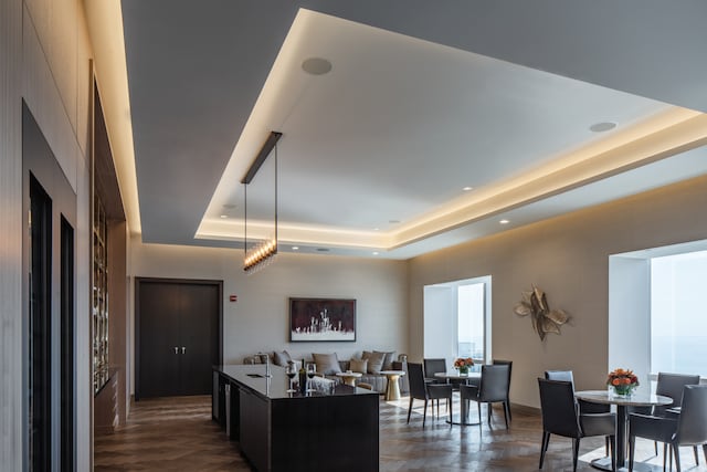 kitchen featuring dark parquet flooring, a raised ceiling, and a kitchen island