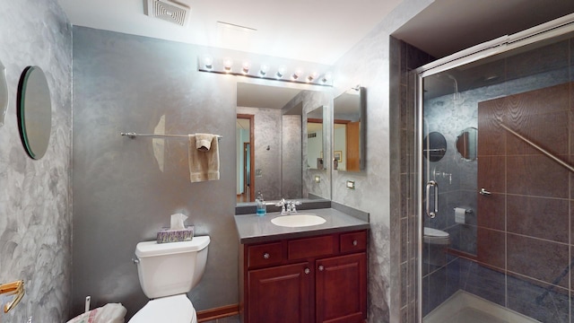 bathroom with visible vents, vanity, a shower stall, and toilet