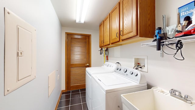 clothes washing area featuring cabinet space, electric panel, washer and dryer, dark tile patterned floors, and a sink