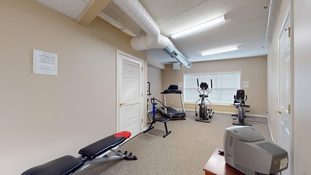 exercise area featuring carpet and baseboards