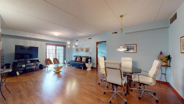 dining room featuring wood finished floors, visible vents, and baseboards