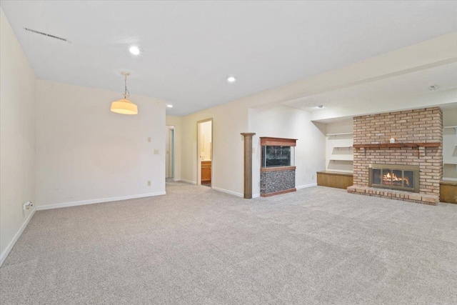 unfurnished living room with built in shelves, light colored carpet, and a brick fireplace