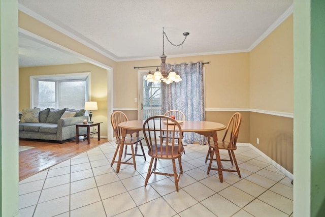 dining room with light tile patterned floors, ornamental molding, and a chandelier