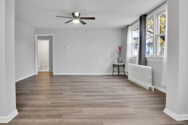 spare room with radiator, ceiling fan, and light hardwood / wood-style floors