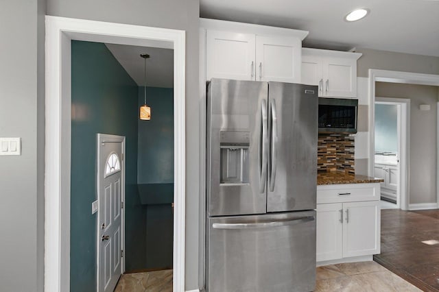 kitchen featuring dark stone counters, white cabinets, decorative backsplash, appliances with stainless steel finishes, and light hardwood / wood-style floors