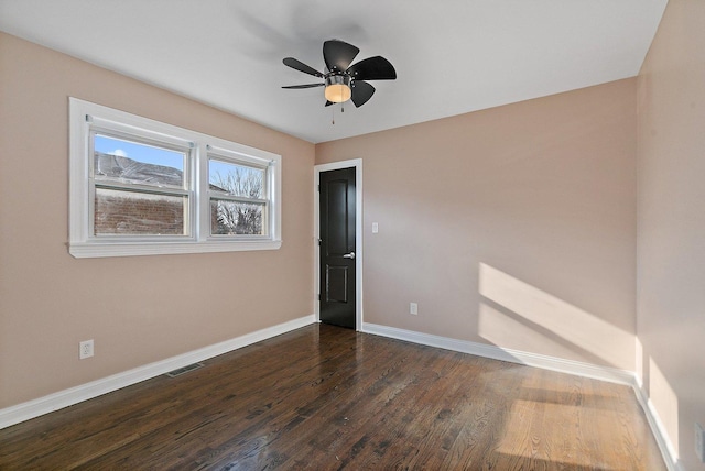 empty room with ceiling fan and dark wood-type flooring