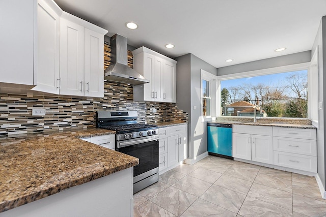 kitchen with white cabinets, wall chimney exhaust hood, decorative backsplash, dark stone countertops, and appliances with stainless steel finishes