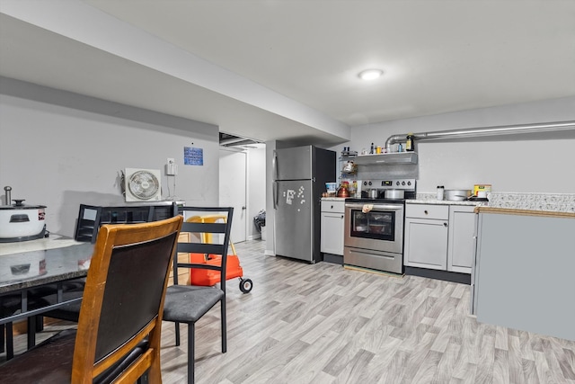 kitchen featuring stainless steel appliances, extractor fan, and light hardwood / wood-style floors