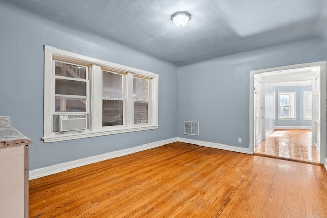 spare room featuring cooling unit and light wood-type flooring