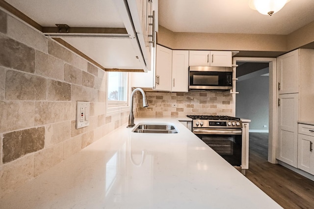 kitchen with sink, decorative backsplash, stainless steel appliances, and white cabinets