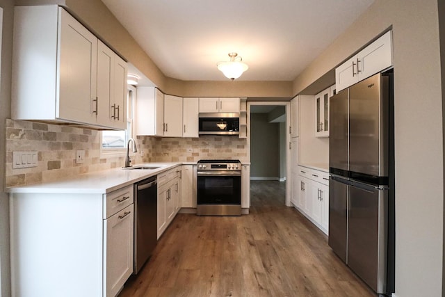 kitchen featuring tasteful backsplash, appliances with stainless steel finishes, sink, and white cabinets