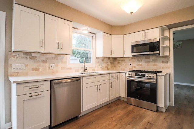 kitchen with sink, white cabinetry, dark hardwood / wood-style flooring, stainless steel appliances, and backsplash