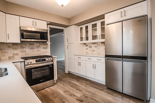 kitchen with appliances with stainless steel finishes, white cabinets, and decorative backsplash