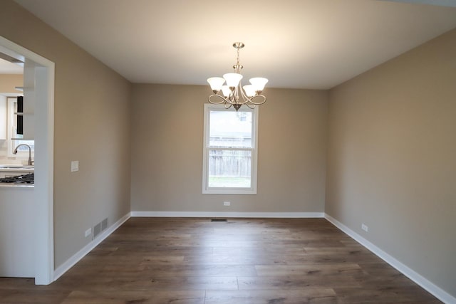 spare room featuring sink, a notable chandelier, and dark hardwood / wood-style floors