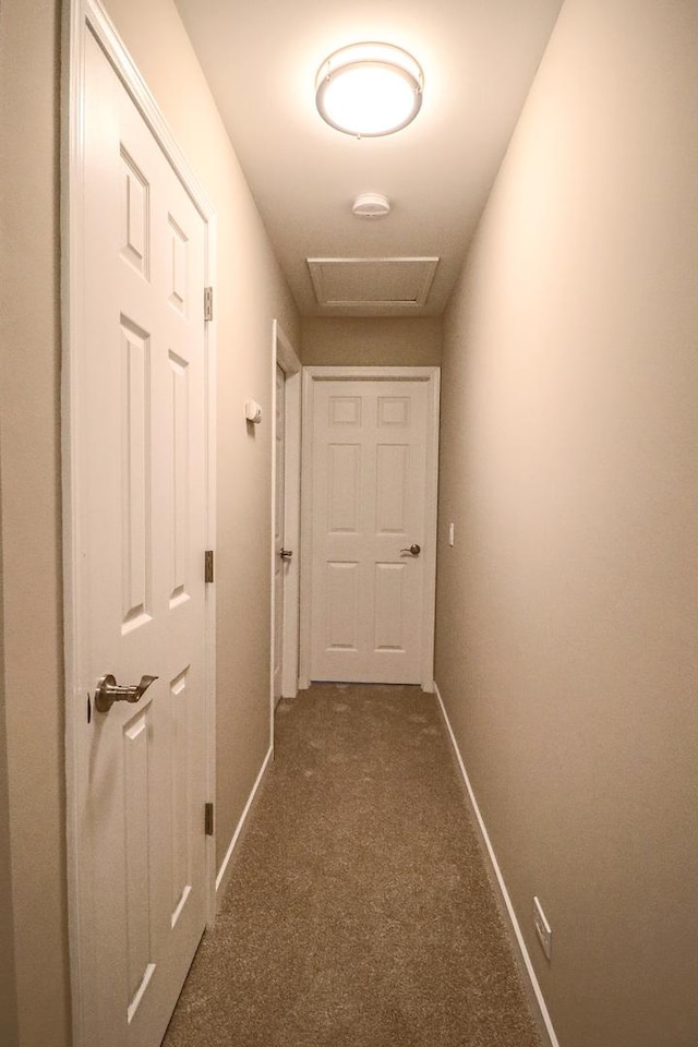 corridor featuring dark colored carpet