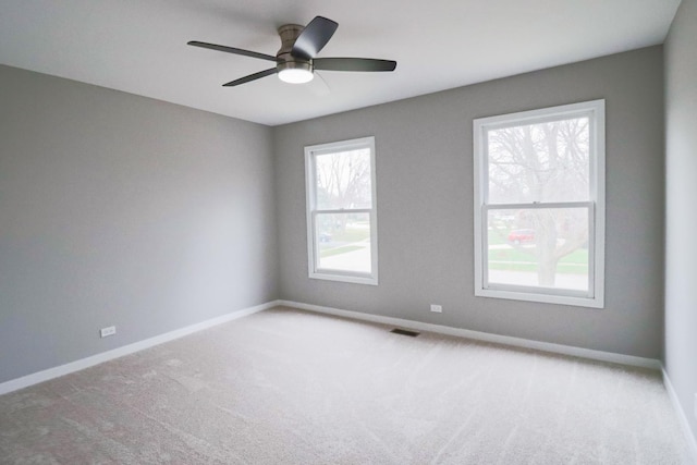 carpeted spare room featuring ceiling fan