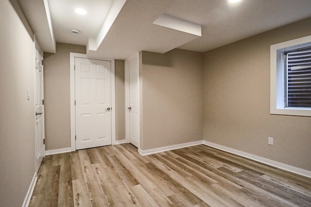 basement with light hardwood / wood-style floors