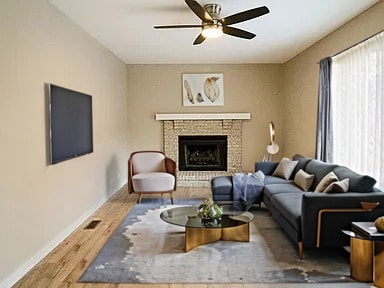 living room featuring a tile fireplace, wood-type flooring, plenty of natural light, and ceiling fan